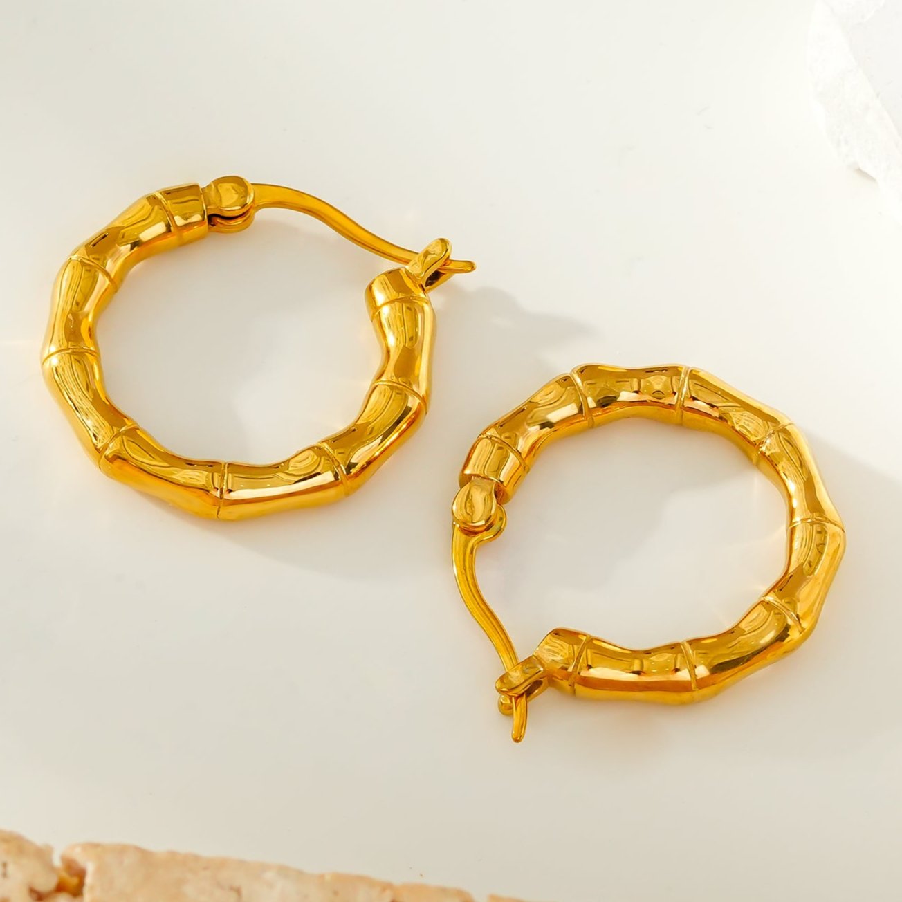 METIOS: Bamboo Textured Hoop Earrings in Gold - Velora Luxury Fashion