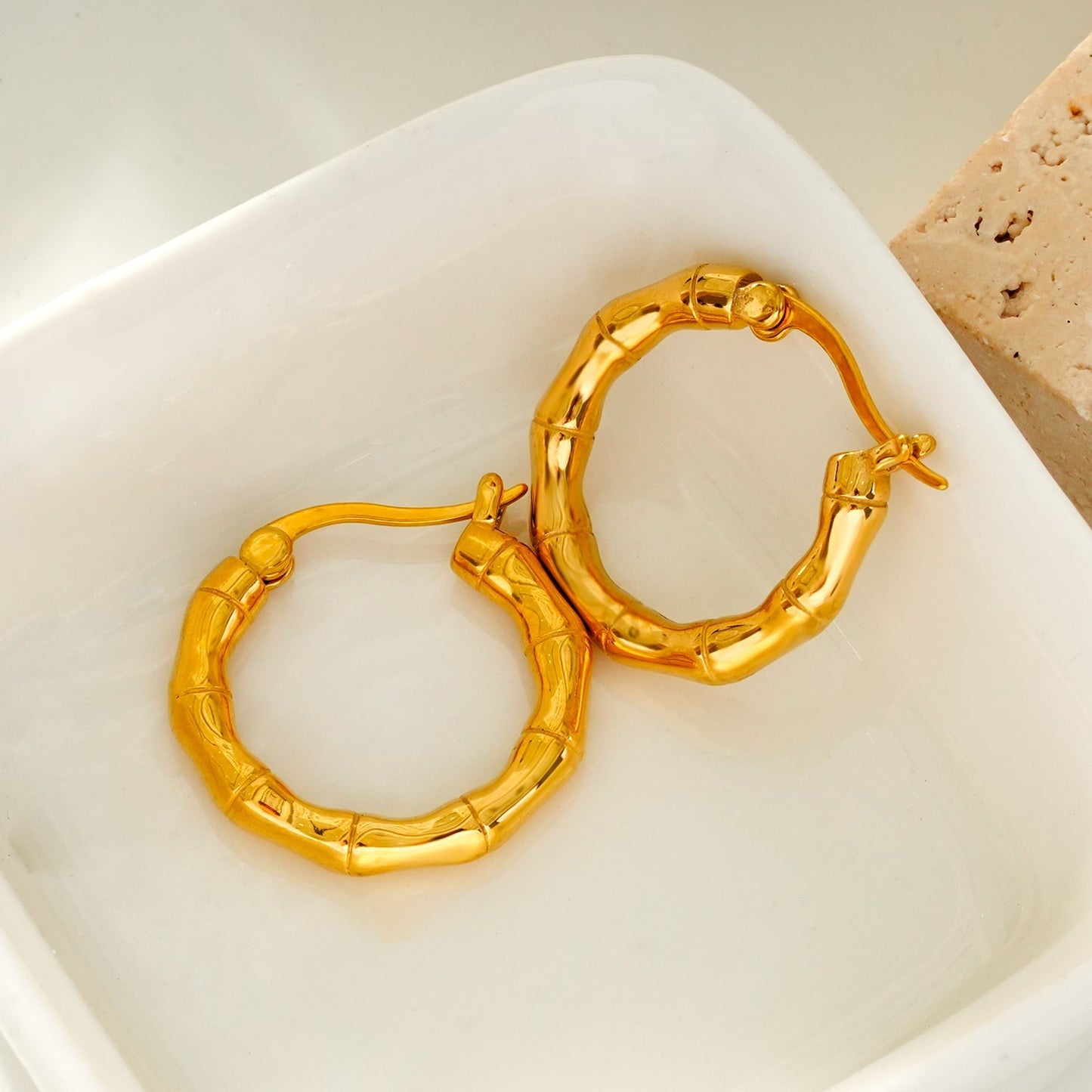 METIOS: Bamboo Textured Hoop Earrings in Gold - Velora Luxury Fashion