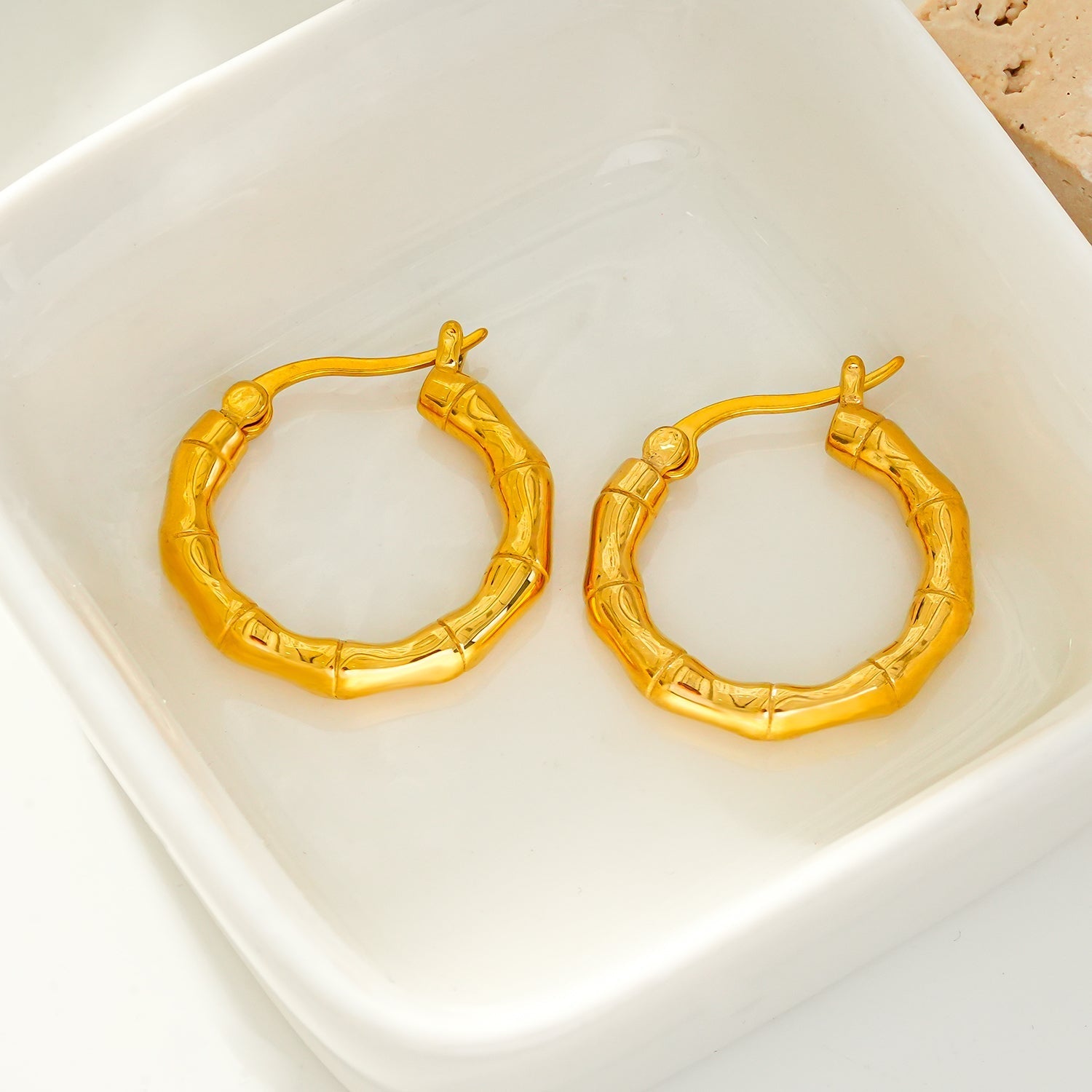 METIOS: Bamboo Textured Hoop Earrings in Gold - Velora Luxury Fashion